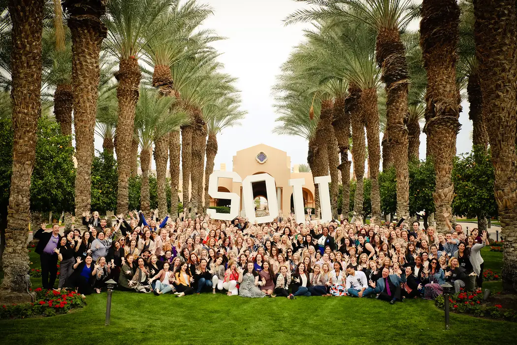 Hundreds of studio owners gathered around giant SOU letters under palm trees